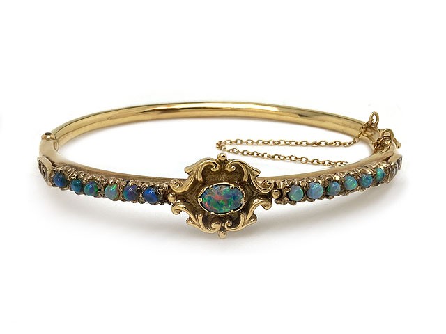 Elaborate opal bangle bracelet with an array of pastel colors in 14k yellow gold. Inner circumference 6.5"
