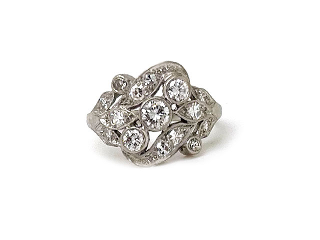 A sparkling diamond ring with a diaganol row of bezel set diamonds and swirl designs.